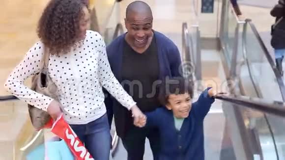 儿童乘坐自动扶梯前往购物中心视频的预览图