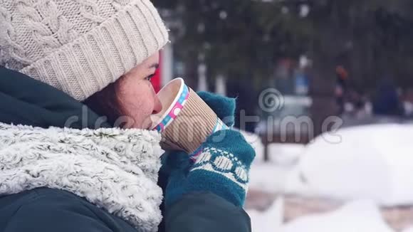 快乐的女人在城市里走来走去在冬天喝咖啡微笑着视频的预览图