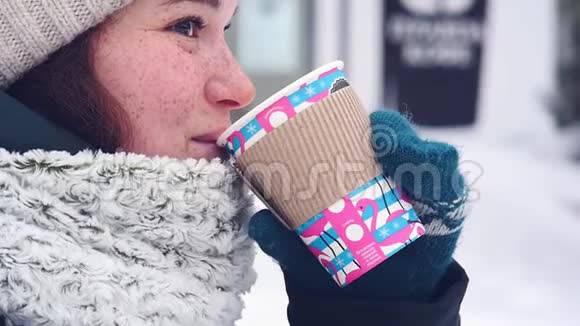 快乐的女人在城市里走来走去在冬天喝咖啡微笑着视频的预览图