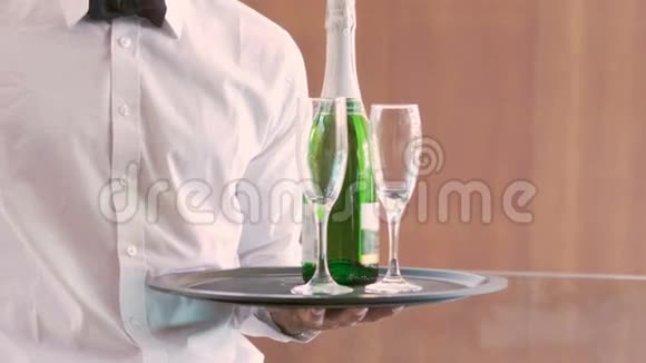 微笑的侍者拿着香槟瓶和长笛视频的预览图