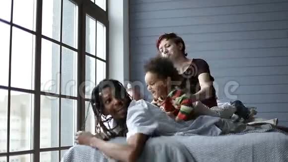 快乐的家庭在卧室里和儿子玩耍视频的预览图