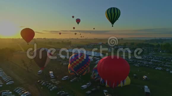早上在气球节上发射热气球的鸟瞰图从填充到起飞视频的预览图