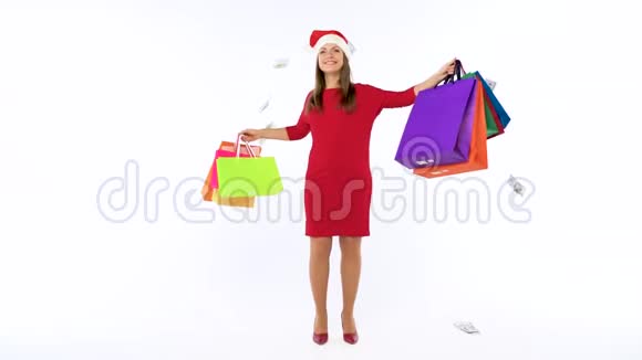 一美元的钞票落在圣诞购物妇女身上她带着五颜六色的购物袋在白色背景下疯狂地跳舞视频的预览图