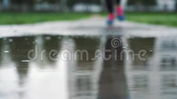 用运动鞋将跑步者腿部的慢动作镜头闭合女运动员在公园户外慢跑踏入视频的预览图