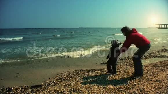 母亲和儿子在海边玩耍视频的预览图