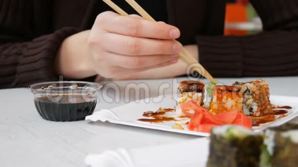 女孩在日本餐馆用筷子吃寿司卷视频的预览图