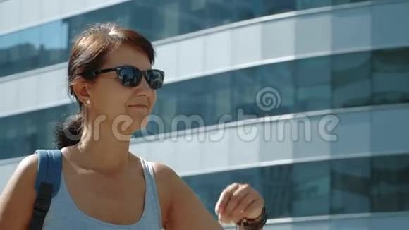 在摩天大楼背景下微笑的女人视频的预览图