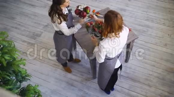两位年轻英俊的厨师花匠在鲜花水果店做水果和蔬菜花束视频的预览图