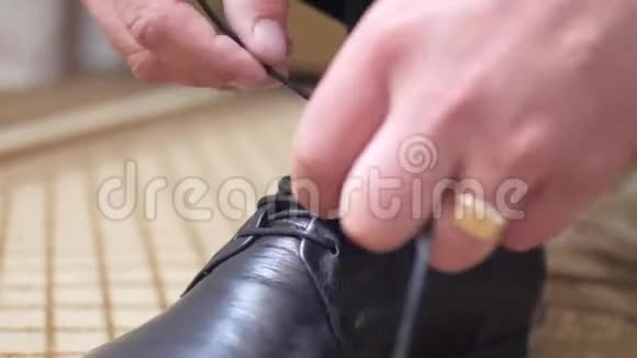 男人把鞋带系在他的黑鞋上视频的预览图