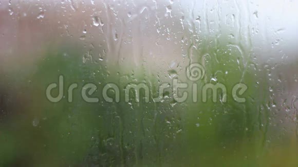 雨和水滴在雨中落在玻璃上关闭视频的预览图