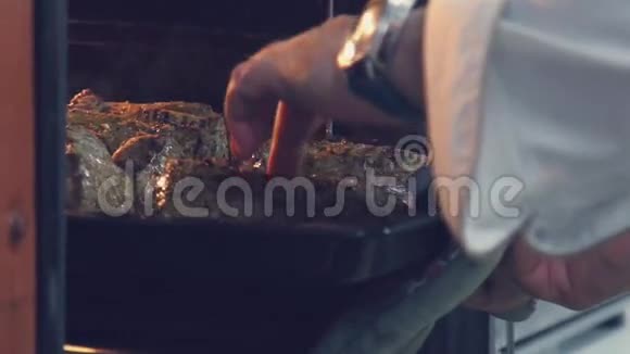 慢动作厨师把锅里的肉放在烤箱里视频的预览图