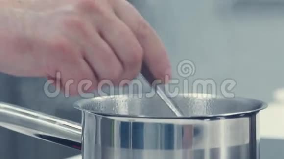 厨师用汤匙把锅里的东西混合在一起视频的预览图