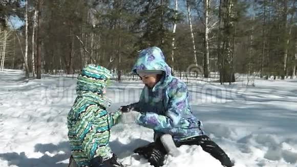 年轻的母亲帮助她的儿子从雪中解脱视频的预览图