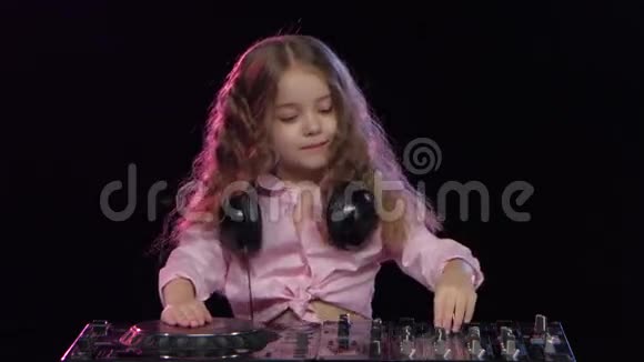 可爱的女孩卷发为DJ控制台播放黑色背景视频的预览图