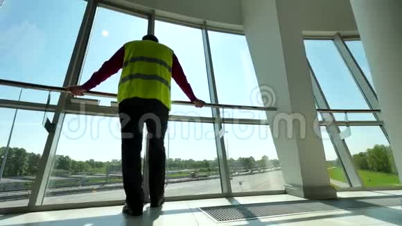 人在反射式安全背心站在调度服务控制室的窗口公路背景视频的预览图