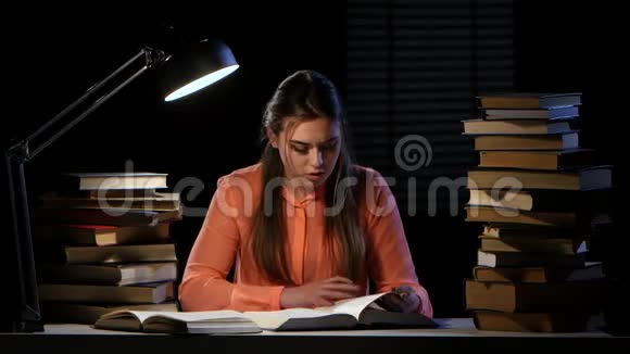 女孩在笔记本上读和写信息黑色背景视频的预览图