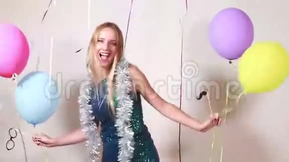 快乐的金发女郎带着气球跳在摄影棚里视频的预览图