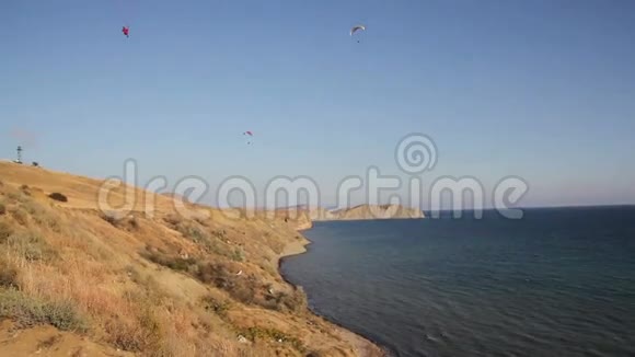 两个滑翔伞在山丘和大海之上视频的预览图