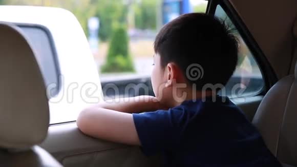 儿童乘车旅行亚洲男孩看窗外停留城市之旅视频的预览图