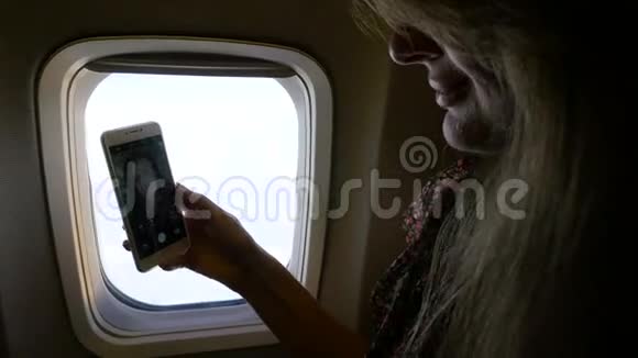 女孩在窗户附近的飞机里自拍高清高清视频的预览图