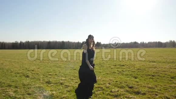 穿着黑色长裙的漂亮女孩在野外散步视频的预览图