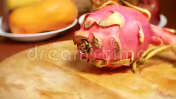 餐桌上的异国水果龙果在切割板上旋转视频的预览图