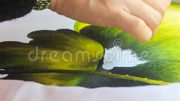 女人的手绣在绿叶上的丝白花视频的预览图