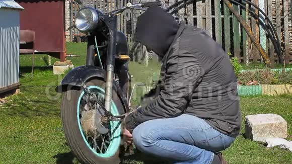 有扳手的人靠近旧摩托车视频的预览图
