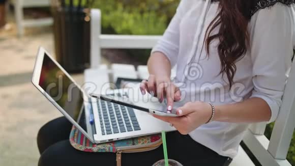 公园里的女士用笔记本电脑和平板电脑视频的预览图