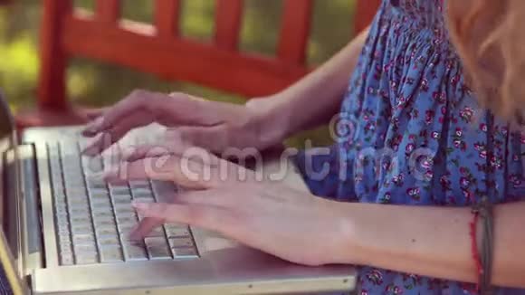 高质量的4k格式漂亮的金发美女在公园里使用笔记本电脑视频的预览图