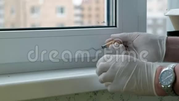 一个戴着橡胶手套的人用刮刀将窗台复原用浆糊涂在破损的地方视频的预览图