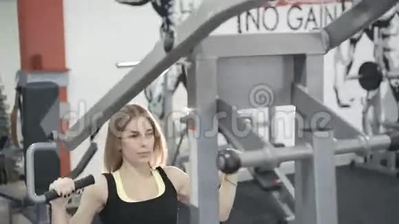 4k女子在健身房锻炼手臂肌肉模拟器视频的预览图