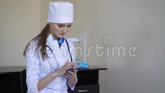 医院里坐着智能手机的年轻女医生视频的预览图
