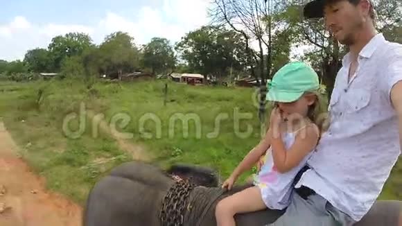 可爱的金发女孩和她的父亲在斯里兰卡骑大象视频的预览图