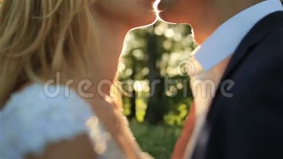 浪漫的新婚夫妇在壮丽的夕阳下温柔地接吻视频的预览图