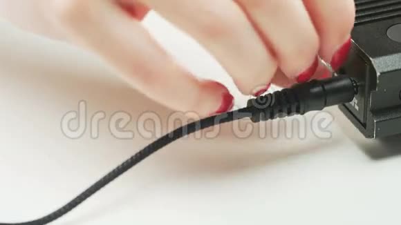 女子将黑色电缆重新插入设备视频的预览图