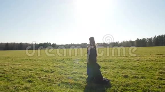 穿着黑色长裙的漂亮女孩在野外散步视频的预览图