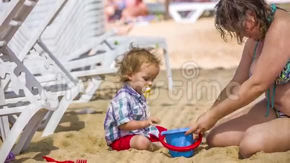 母亲和婴儿在沙滩上玩耍视频的预览图