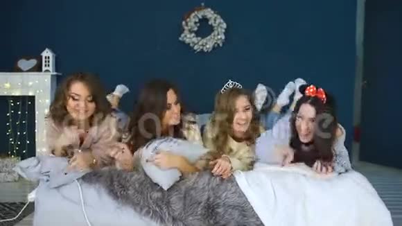 四个美丽的女孩躺在床上微笑女朋友在卧室里玩得开心视频的预览图