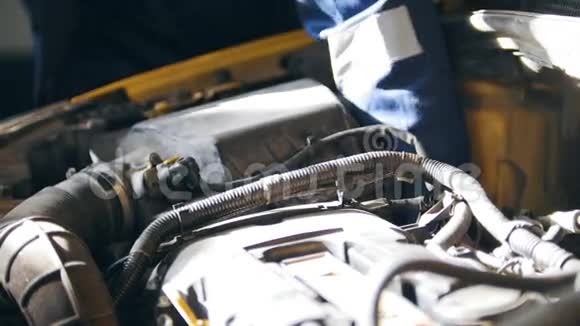 汽车的罩发动机电池喷油器机械师在汽车服务中工作视频的预览图