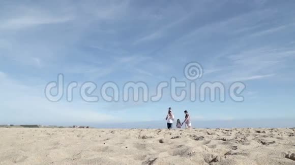 母亲和父亲带着孩子在海滩上奔跑视频的预览图