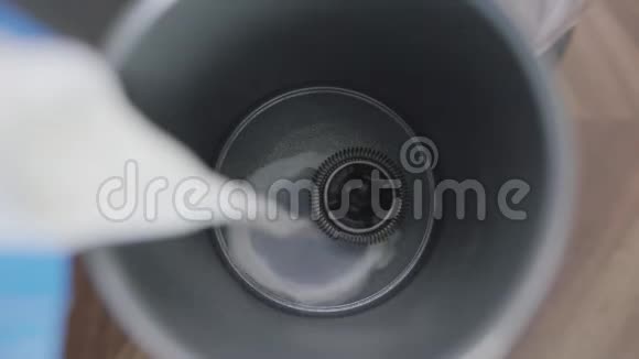 牛奶倒入金属电动牛奶泡沫底部有小搅拌器视频的预览图