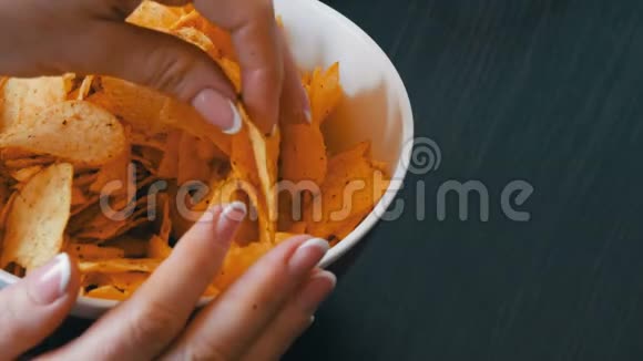 桌子上有薯片的大盘子美甲女性手拿薯片视频的预览图