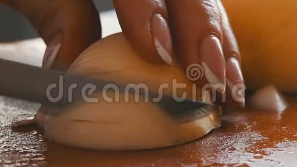 女人在厨房的木板上切洋葱视频的预览图