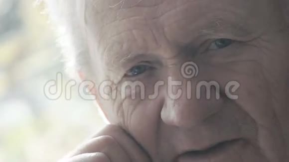 特写疲惫的快乐老人在镜头前微笑的画像视频的预览图
