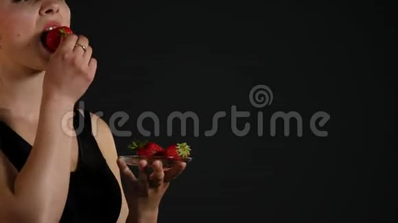 年轻快乐的女孩带着黑色的草莓视频的预览图