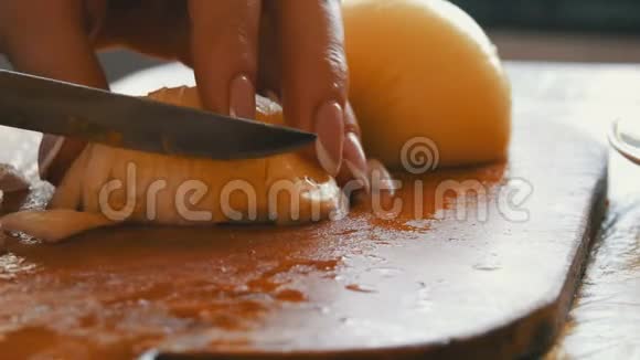 女人在厨房的木板上切洋葱视频的预览图