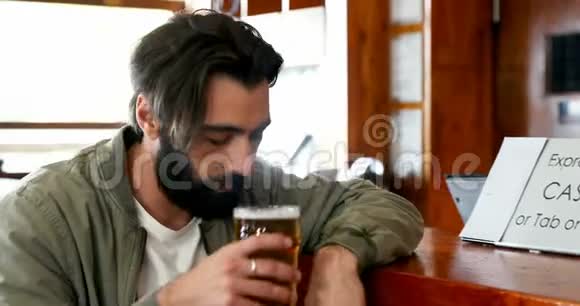 男子在喝啤酒时使用手机视频的预览图