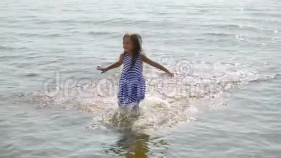 穿着条纹连衣裙跑海的小女孩视频的预览图