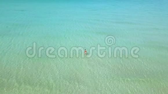 蓝色海景的年轻女子无人机在透明的海水中观看女人俯视绿松石水视频的预览图